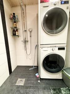 een wasmachine en droger in een kleine badkamer bij Rubin Apartment in Kajaani
