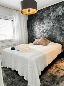een slaapkamer met een wit bed en een muurschildering bij Rubin Apartment in Kajaani