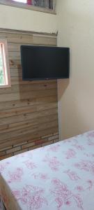 1 dormitorio con 1 cama y TV de pantalla plana en Morada Sol e Lua Container Guarda do Embaú com Ar condicionado en Guarda do Embaú