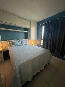 a bedroom with a large bed with a blue wall at Cumbuco Ap VGSUN 402 in Cumbuco