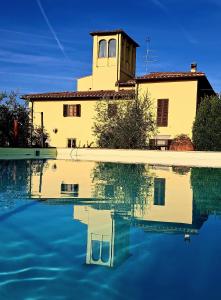 ein Gebäude mit einer Reflexion in einem Wasserpool in der Unterkunft Agriturismo Villa Guarnaschelli in Scandicci