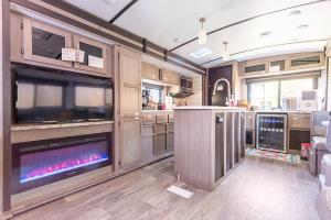 an rv kitchen with a fireplace and a tv at The River RV in Smithville