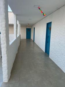 an empty hallway of a building with blue doors at KEFI POUSADA in Maragogi