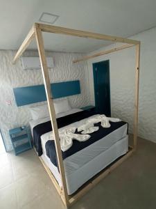 KEFI POUSADA في ماراغوغي: غرفة نوم مع سرير بطابقين وإطار خشبي