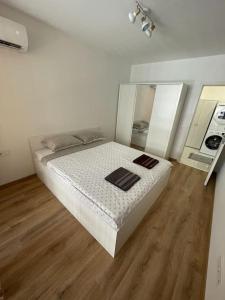 a white bedroom with a bed in a room at Двустаен апартамент за двама. in Burgas