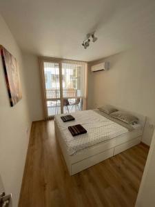 1 dormitorio con 1 cama y suelo de madera en Двустаен апартамент за двама., en Burgas
