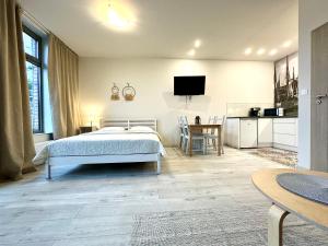 a bedroom with a bed and a kitchen with a table at Apartamenty Marea Rentals Bulwar Portowy Ustka in Ustka