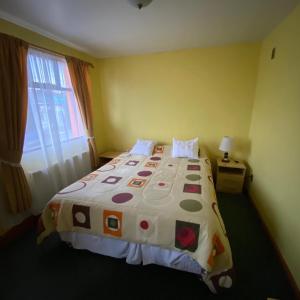 een slaapkamer met een groot bed en een kleurrijk dekbed bij Hotel Yagan Porvenir in Porvenir