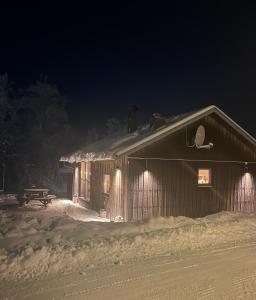 um edifício coberto de neve à noite com luzes em Fjällstuga Huså em Åre