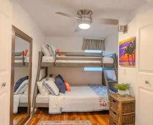a room with two bunk beds and a mirror at Beachfront Condo with AC in Laie