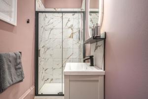 La salle de bains est pourvue d'un lavabo et d'une douche. dans l'établissement Boutique Home Stay Blossom, à Paisley