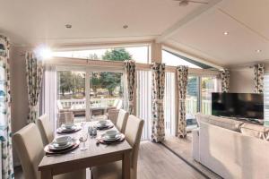 a dining room with a table and a large window at Woodland Jewel Lodge with Hot Tub in York