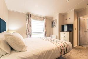Un dormitorio con una cama grande y una ventana en Woodland Jewel Lodge with Hot Tub, en York