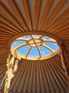 una ventana redonda en una yurta con techo en Wilding Yurt Stay, en Broughton in Furness