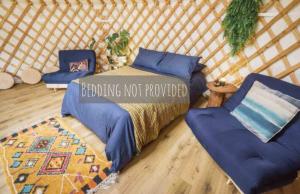 a bed and two chairs in a yurt at Wilding Yurt Stay in Broughton in Furness