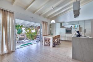 a large kitchen with a counter and a table at Beach Villa by Bobbywashere in Santa Maria