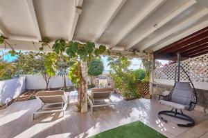 an outdoor patio with chairs and a tree at Beach Villa by Bobbywashere in Santa Maria