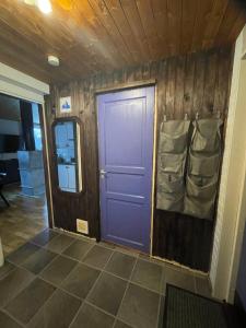 uma porta roxa num quarto com piso em azulejo em Fjällstuga Huså em Åre