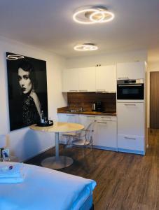 eine Küche mit einem Tisch und einem Bild einer Frau in der Unterkunft Casa Bella Metzingen in Metzingen
