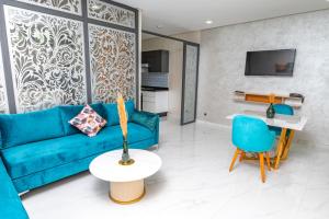 a living room with a blue couch and a table at Maarif elite suites in Casablanca