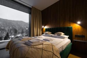 a bedroom with a large bed with a large window at PROSTIR in Korostov