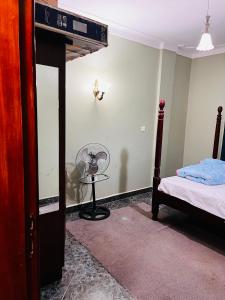 坎帕拉的住宿－Kampala Flat，卧室配有一张床,墙上配有风扇