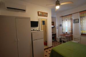 Habitación con cama, nevera y escritorio. en Lipari Monolocale centro storico, en Lipari