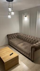 a large brown couch in a room with a table at Central Boulevard Apartment 2 in Šiauliai