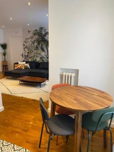 un salon avec une table et des chaises en bois dans l'établissement Un nid douillet- parking privé-résidence fermée-45m2, à Aubervilliers