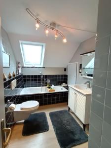 ein Badezimmer mit einer Badewanne, einem WC und einem Waschbecken in der Unterkunft Haus Tourneur in Lippetal