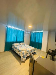 a bedroom with a bed and blue curtains at BLUE ISLAND HOTEL in San Andrés