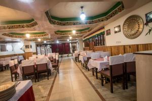 a dining hall with tables and chairs in a restaurant at Central Hill Resort The Mall Road in Gangtok