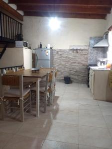a kitchen with a wooden table and chairs and a stove at La Catalina 2 in San Antonio de Areco