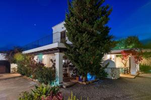 ein weißes Haus mit einem Baum davor in der Unterkunft 8 Guests Large Villa near Bossa Beaches & Airport in San Jose de sa Talaia