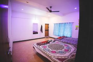 a bedroom with a large bed and a ceiling fan at Gokul farm house in Sasan Gir