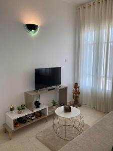 een woonkamer met een tv en een tafel bij Residence-Sassi in Nabeul