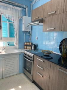 a blue kitchen with a stove and a sink at Residence-Sassi in Nabeul