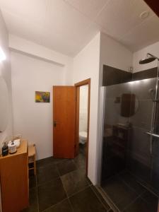 uma casa de banho com um chuveiro e uma porta de madeira em Spói Guesthouse em Hvolsvöllur