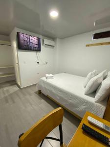 1 dormitorio con 1 cama y TV en la pared en Hotel Alameda Plaza, en Cali