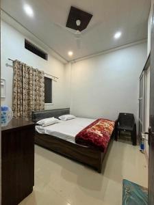 a bedroom with a bed and a desk and a ceiling at Madhuri Guest House in Varanasi