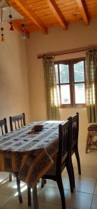 a dining room with a table and chairs and a window at Maimará Jujuy in Maimará