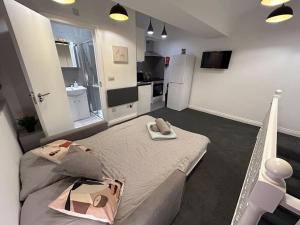 a bedroom with a large bed and a kitchen at City Studio Escape near Emirates in London