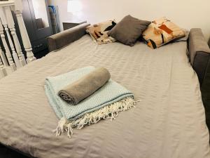 a bed with two towels and pillows on it at City Studio Escape near Emirates in London