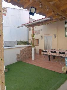 patio ze stołem i zieloną trawą w obiekcie Casa de pueblo con piscina w mieście El Acebrón