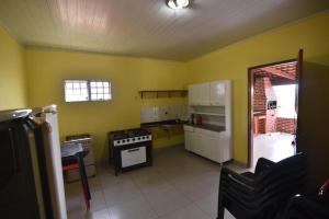 uma cozinha com paredes amarelas e um forno com placa de fogão em Recanto Minas a Goiás em Ceres