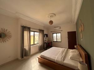 a bedroom with a bed and a window at Cocoon Guest House in Cotonou