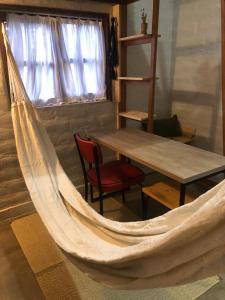 a hammock in a room with a table and a chair at Yê Tiny Houses in Palmeiras