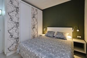 ein Schlafzimmer mit einem Bett und einer grünen Wand in der Unterkunft Penthouse Inlakesh in Valencia