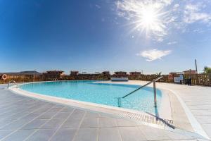een groot zwembad met de zon in de lucht bij Villa Colibri Dorado in Lajares