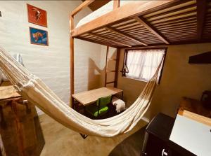 a hammock in a room with a desk and a bed at Yê Tiny Houses in Palmeiras